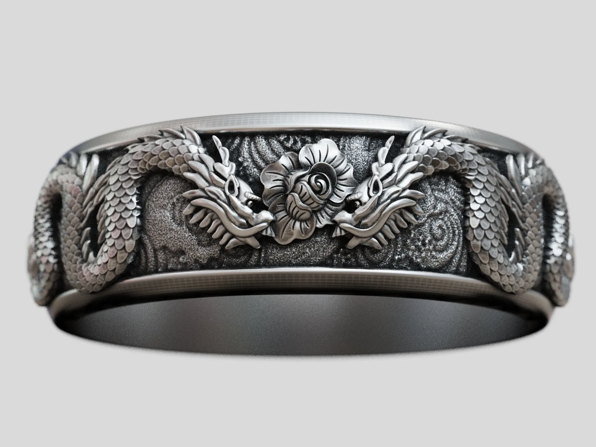 Silver band ring featuring a detailed dragon and flower design, symbolizing power and beauty, perfect for those who embrace a bold style.