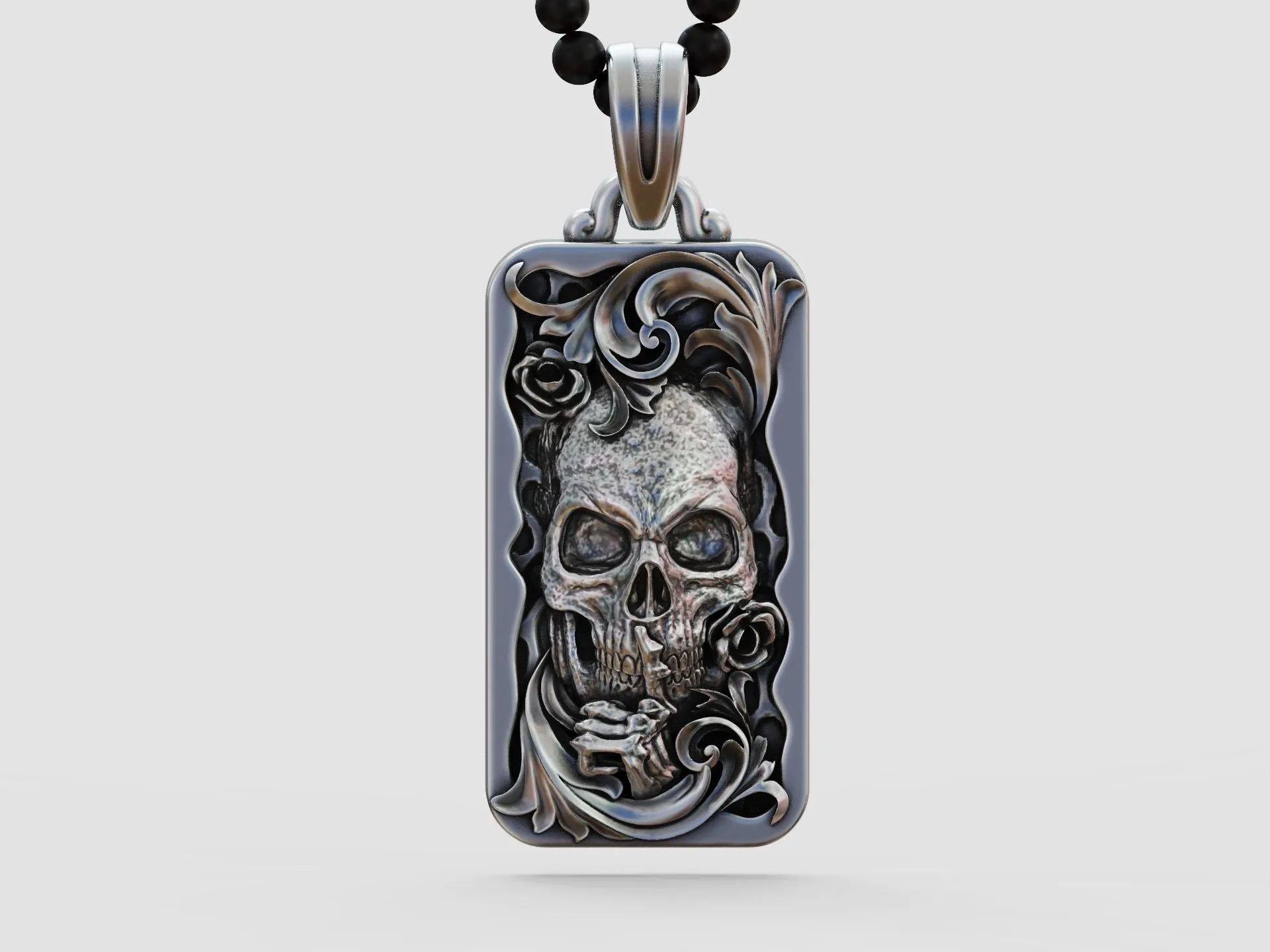 Silver pendant featuring a skull with floral scrolls and roses, blending gothic elements with botanical motifs.