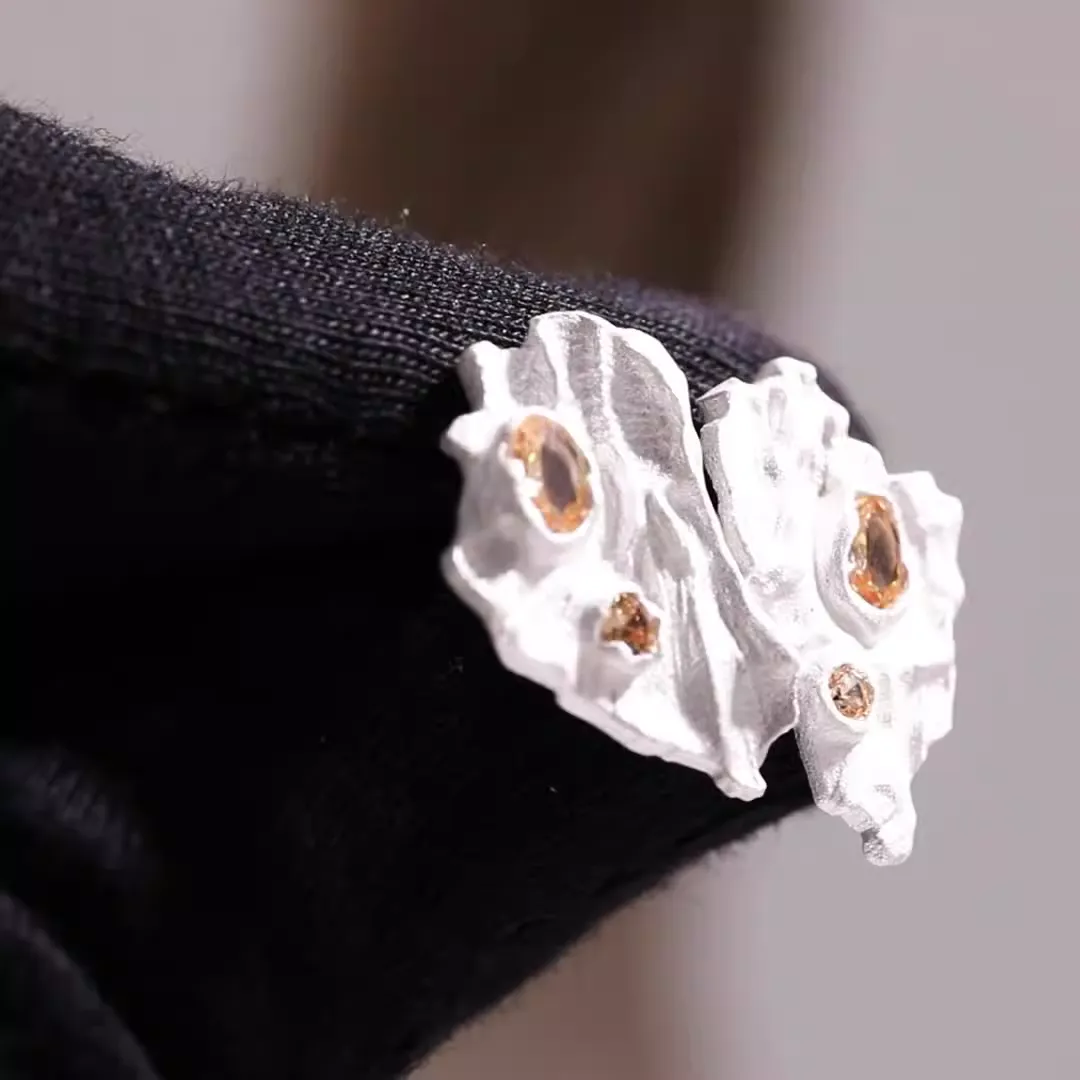 Crystalline textured stud earrings in gold and silver with sparkling crystals.