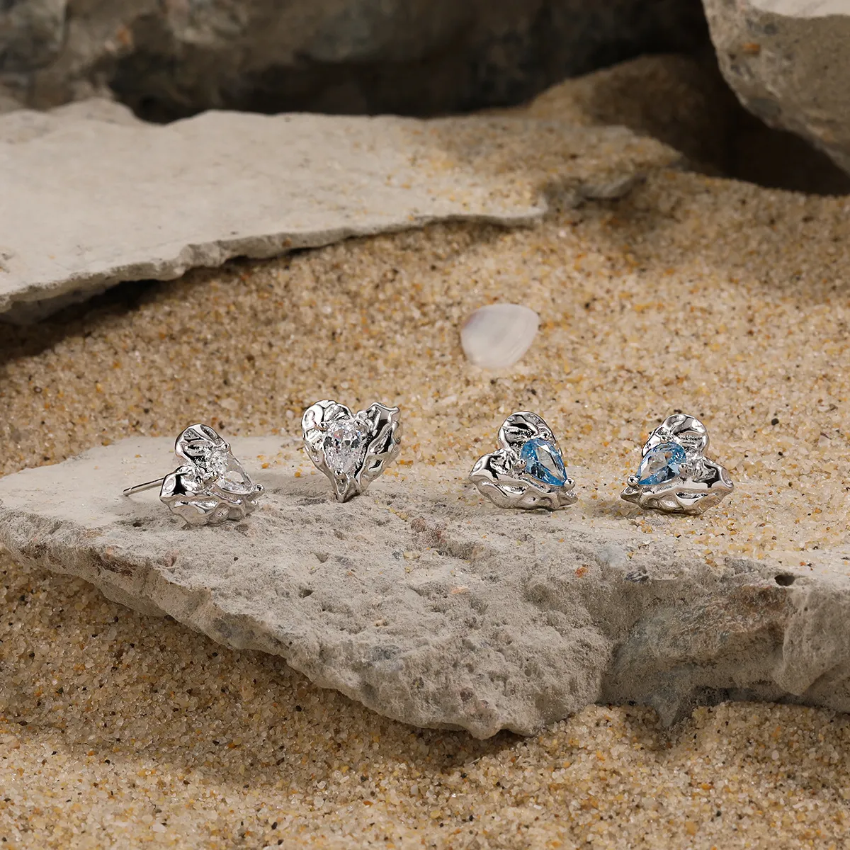 Heart-shaped silver stud earrings with sparkling zircon stones.